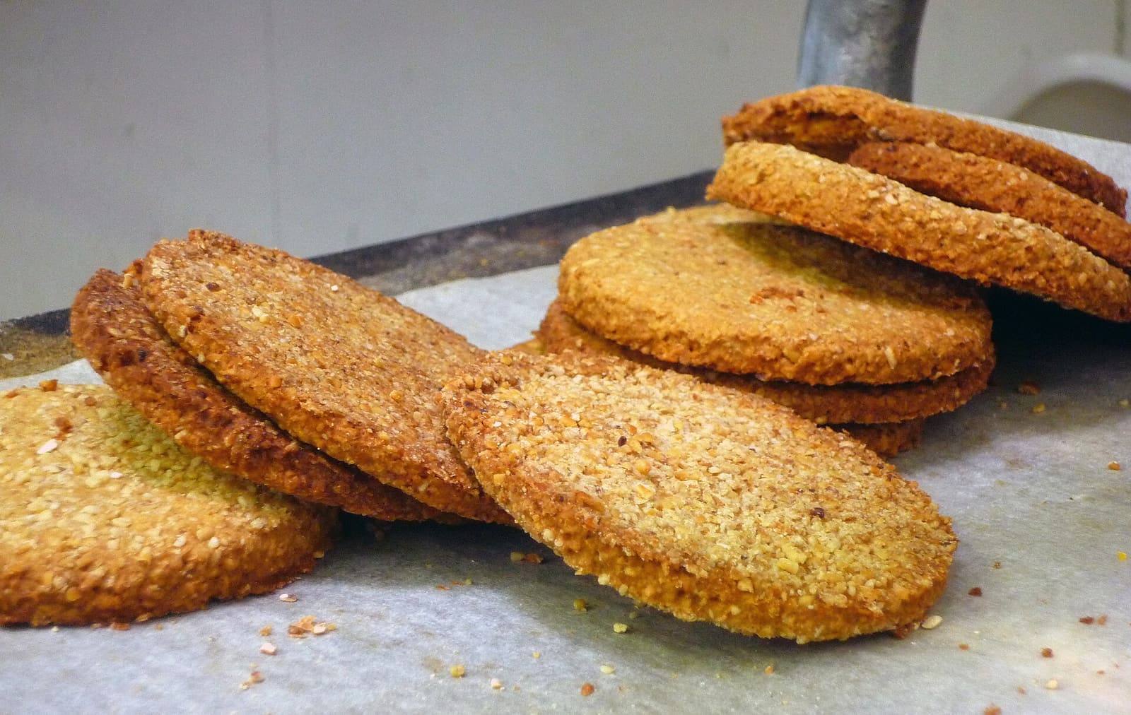 A loose stack of thick, round, golden oatcakes on baking paper.